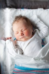 Newborn baby sleeping in hospital bassinet