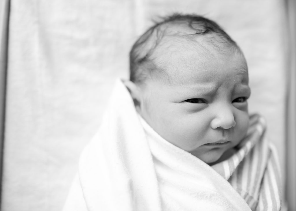 Newborn baby making a scowling face