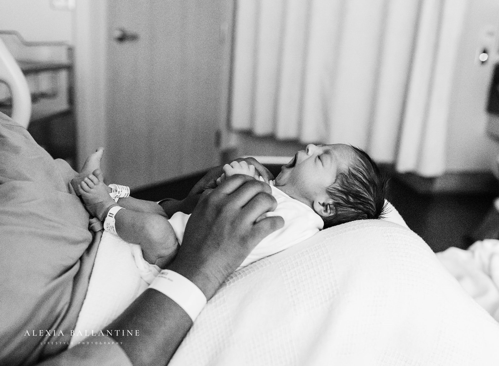 Baby yawning on mothers lap