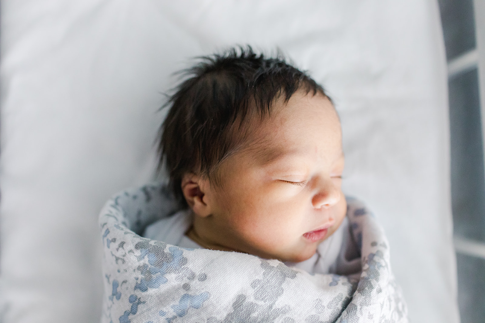 Newborn baby laying in bassinet