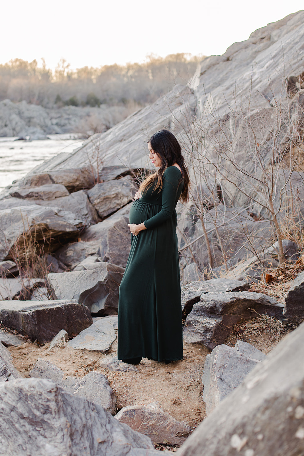 couple expecting a baby being photographed by a river