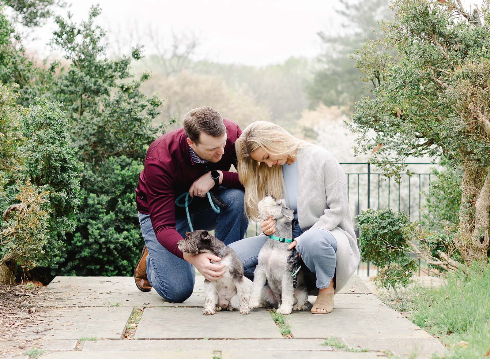 couple with their dogs standing in a garden