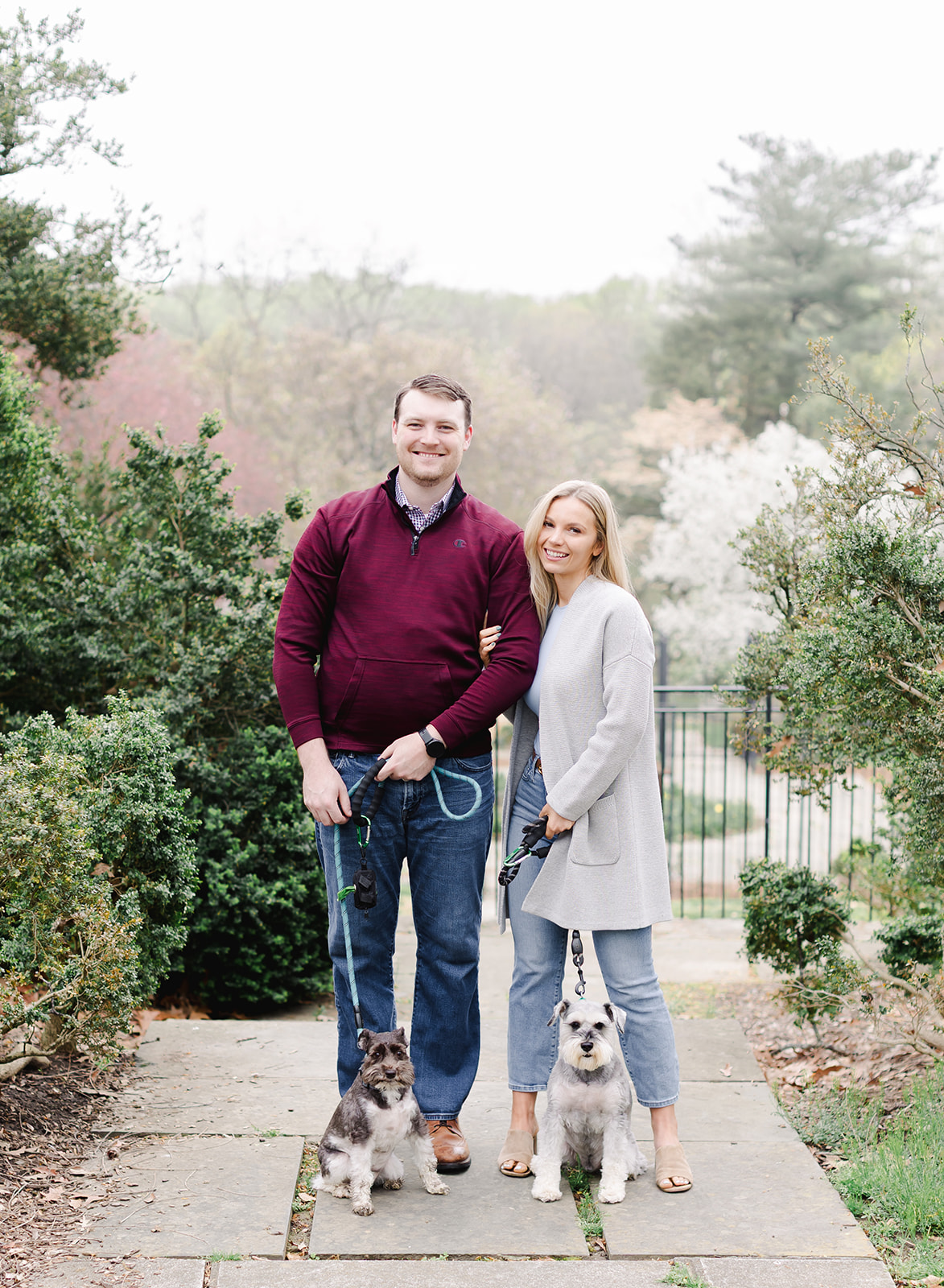 couple with their dogs standing in a garden