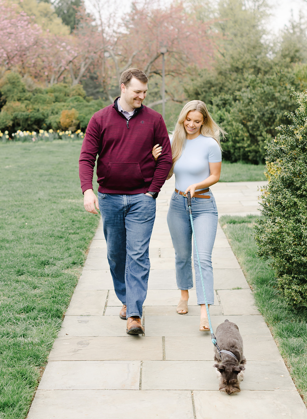 family with their two dogs walking in a garden