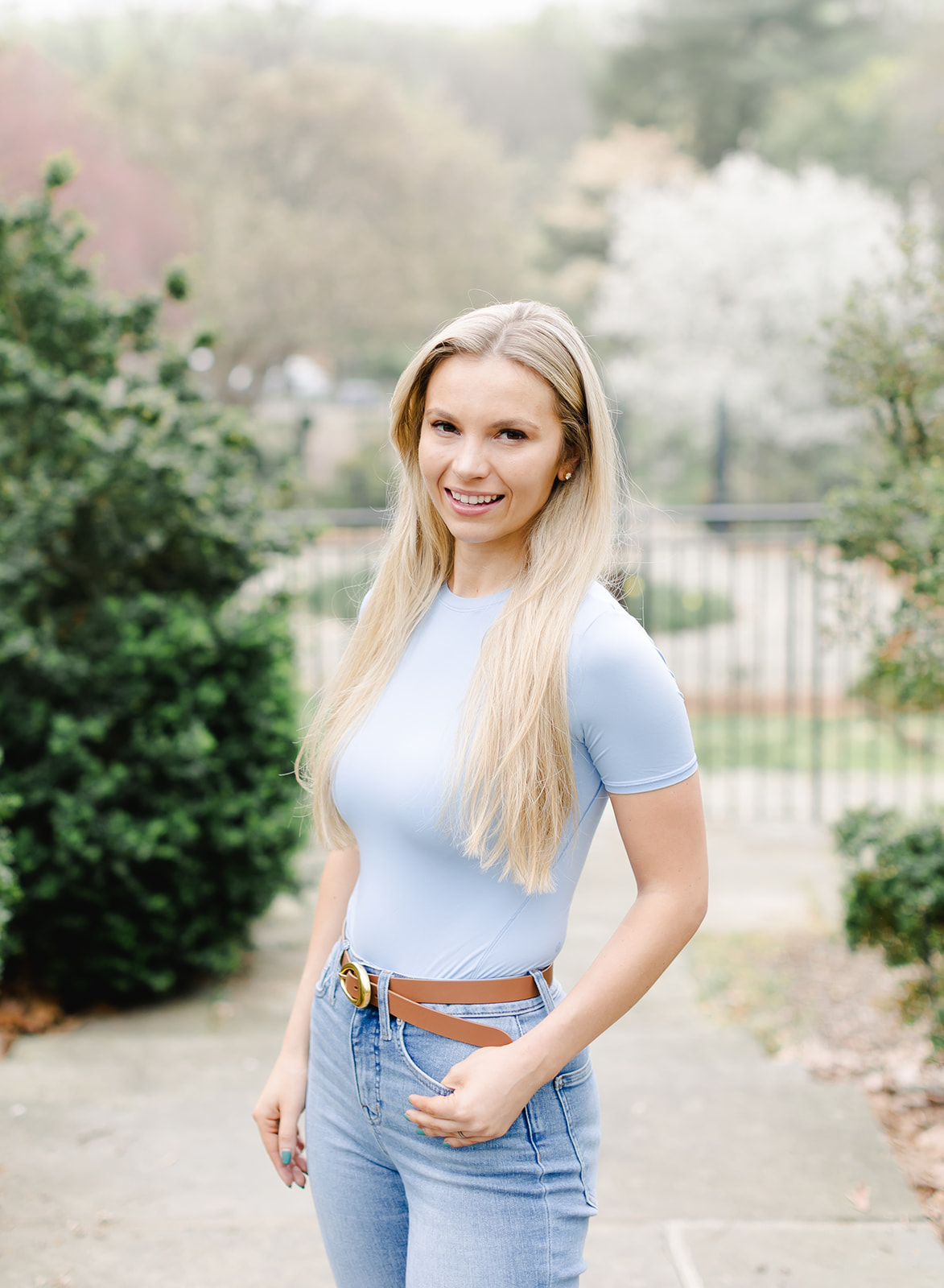 headshot of a beautiful blonde woman wearing a blue shirt and jeans