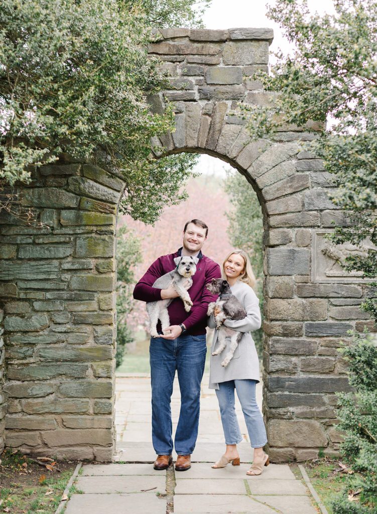 couple with their dogs standing in a garden