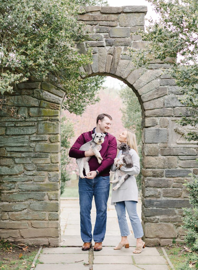 couple with their dogs standing in a garden