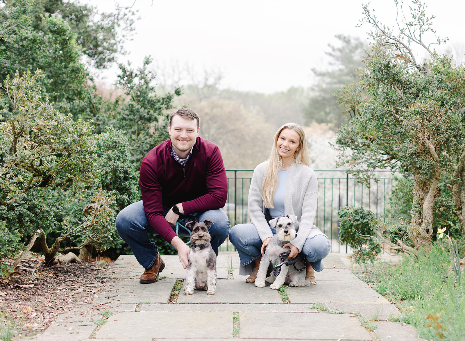 couple with their dogs standing in a garden