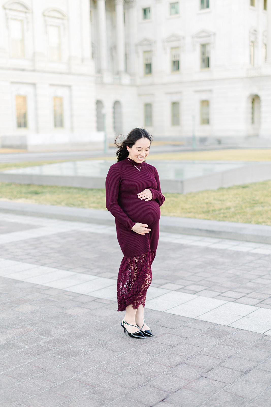 Pregnant mom in a maroon dress in front of the US capital