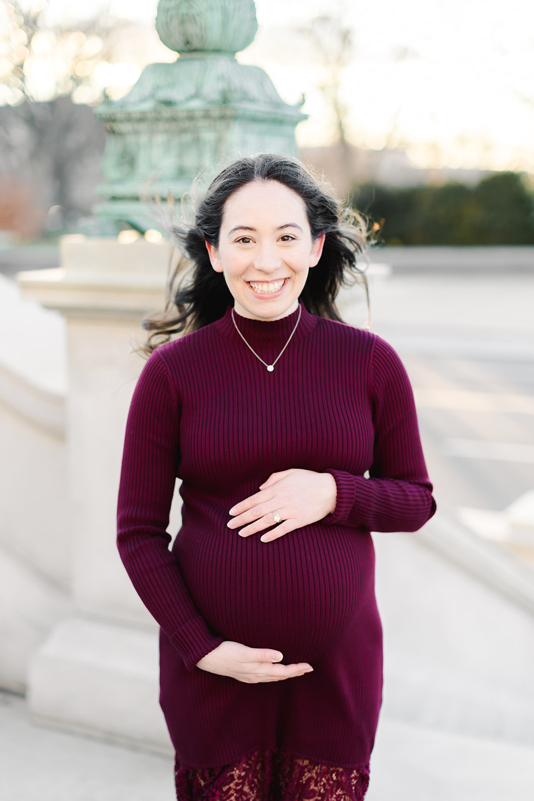 Pregnant mom in a maroon dress in front of the Library of Congress