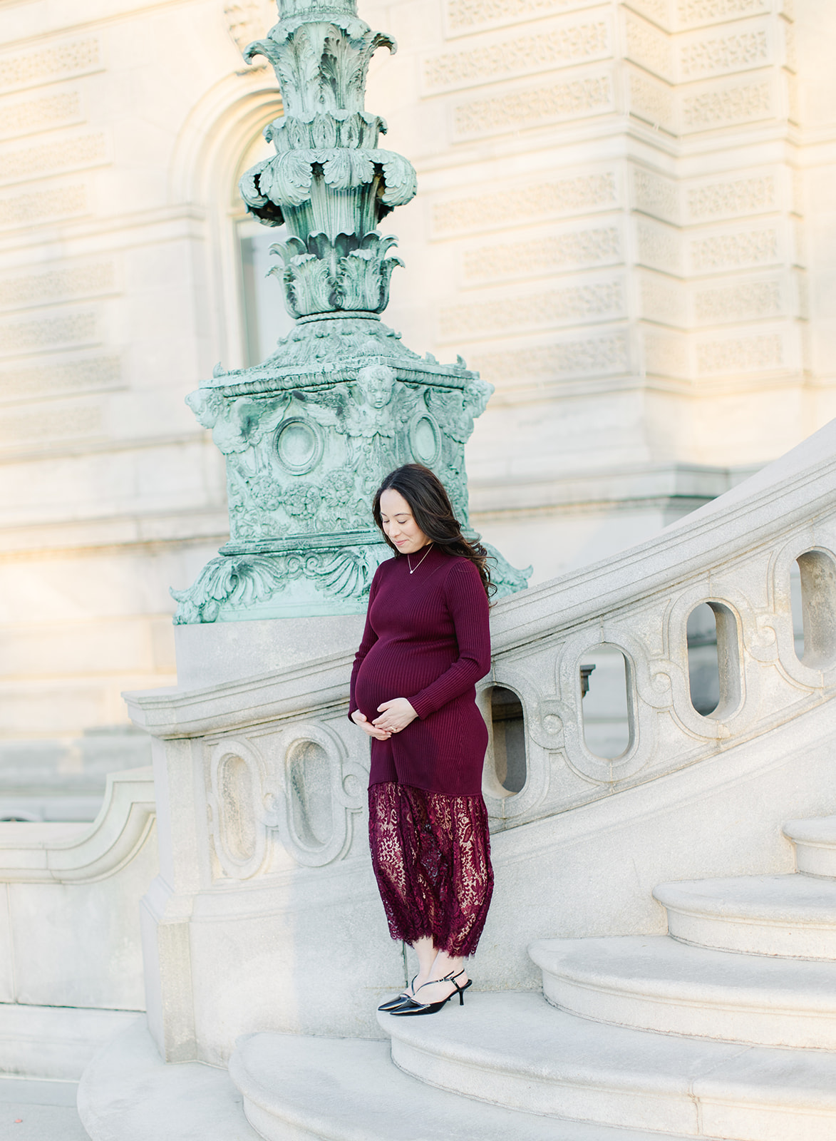 Pregnant mom in a maroon dress in front of the Library of Congress