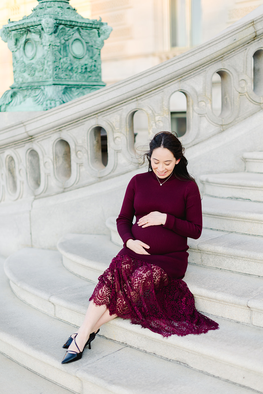 Pregnant mom in a maroon dress in front of the Library of Congress