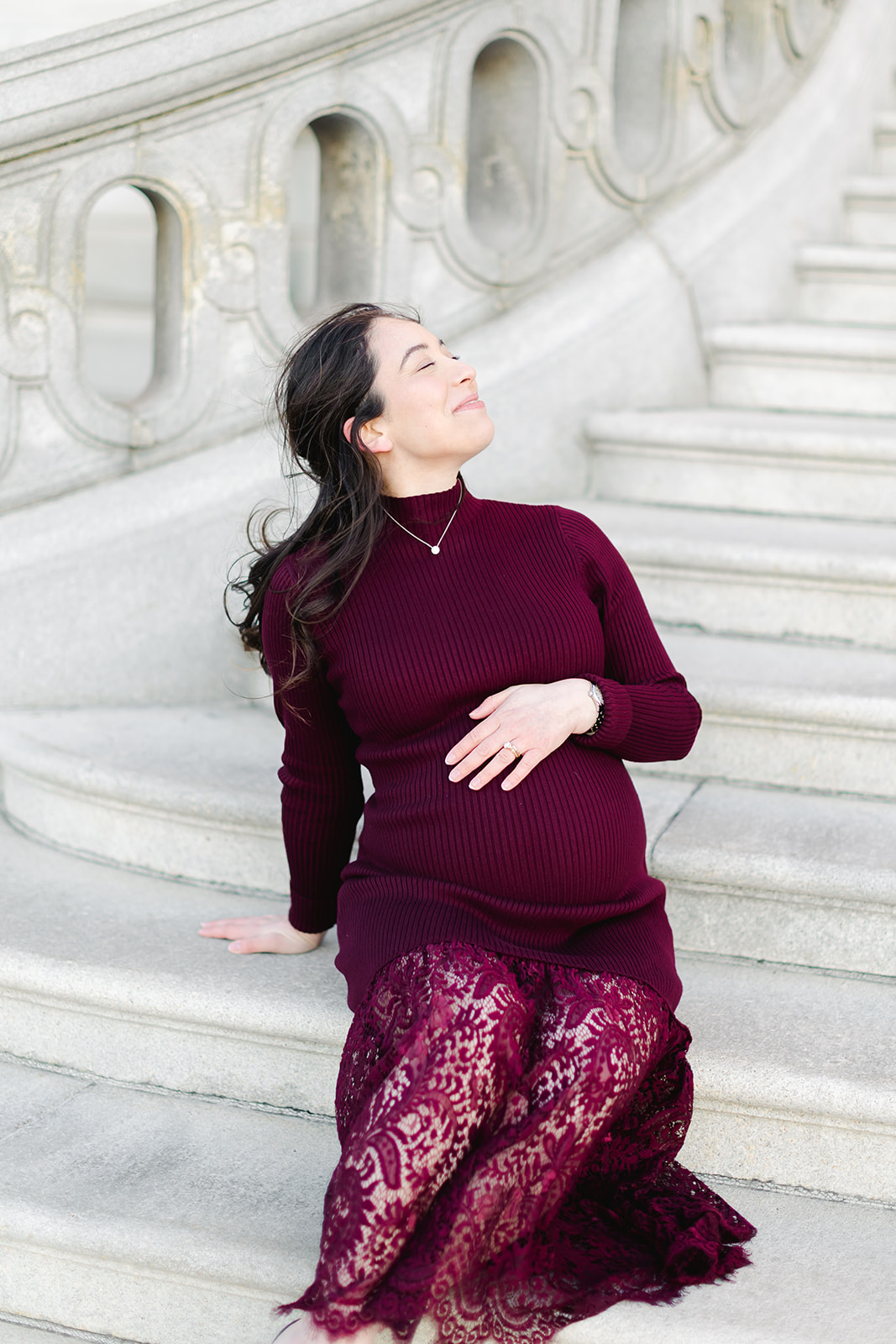 Pregnant mom in a maroon dress in front of the Library of Congress