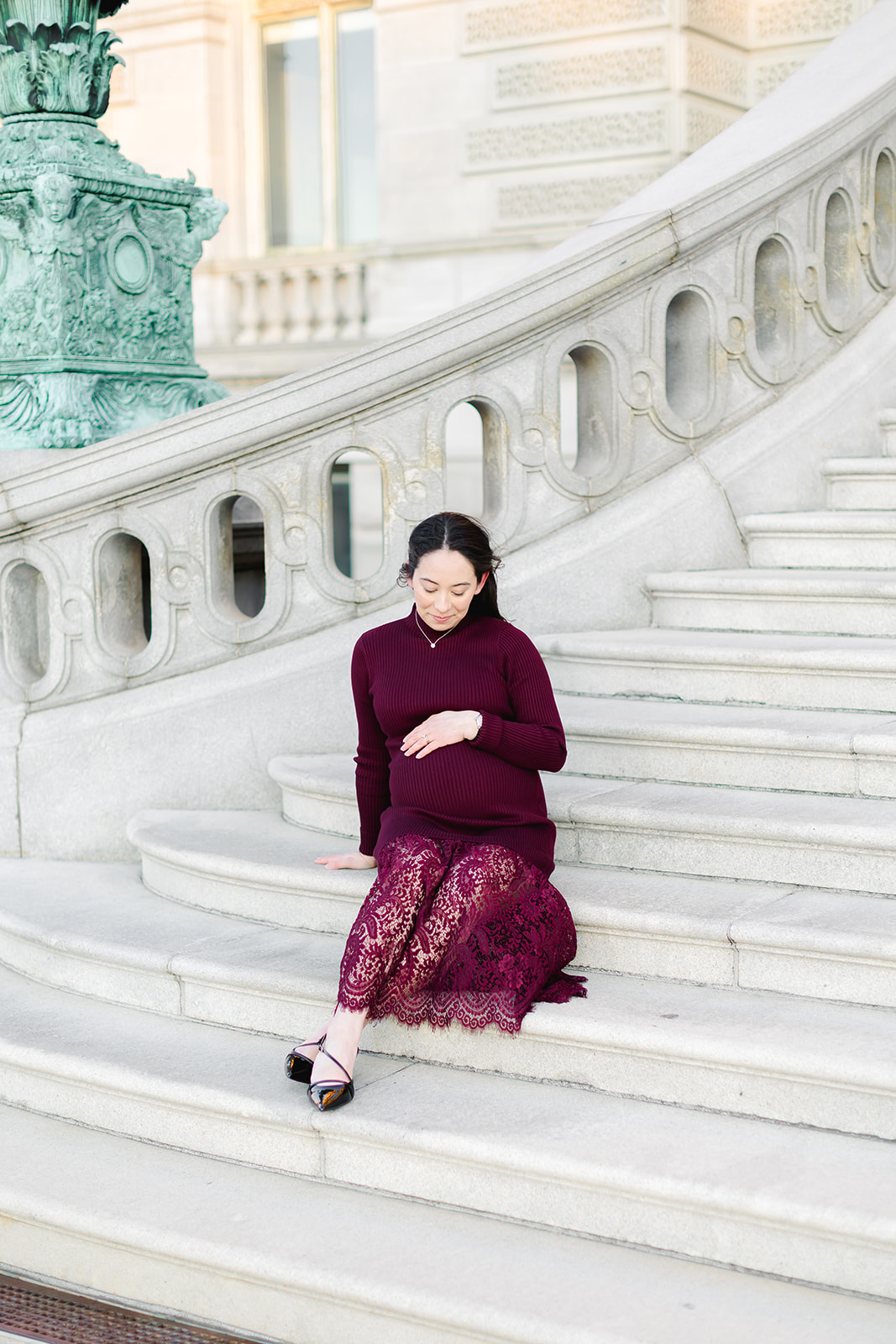 Pregnant mom in a maroon dress in front of the Library of Congress
